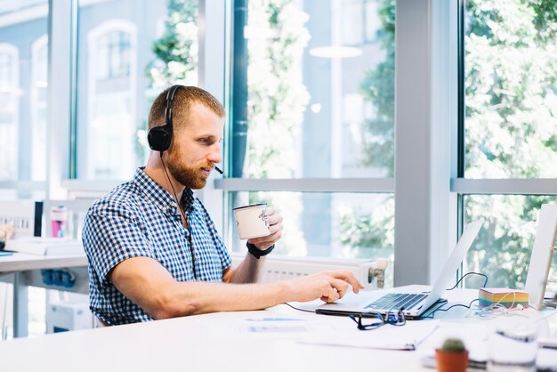 Hombre en auriculares para beber y trabajar