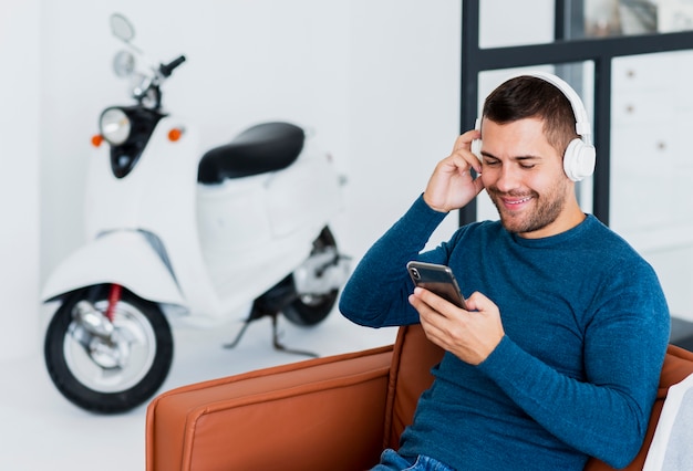 Hombre con auriculares comprobando la música del teléfono