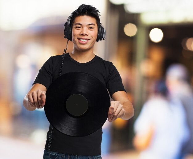 Hombre con auriculares y un disco de vinilo