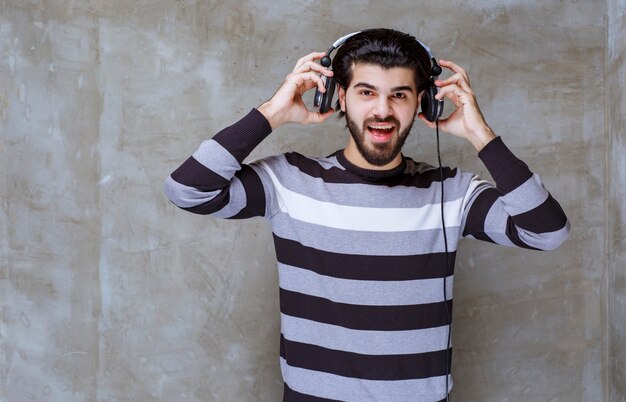 Hombre con auriculares escuchando música y sonriendo