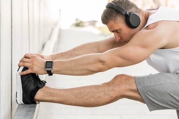 Hombre con auriculares estirando afuera