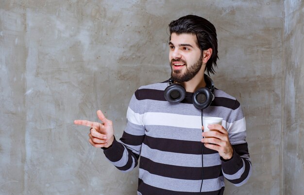 Hombre con auriculares interactuando con alguien a un lado