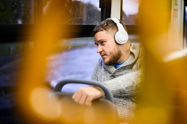 Foto gratuita hombre con auriculares viajando en bus