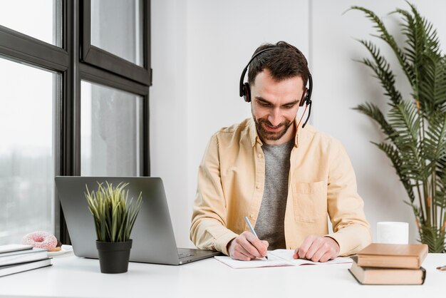 Hombre con auriculares con videollamada en portátil