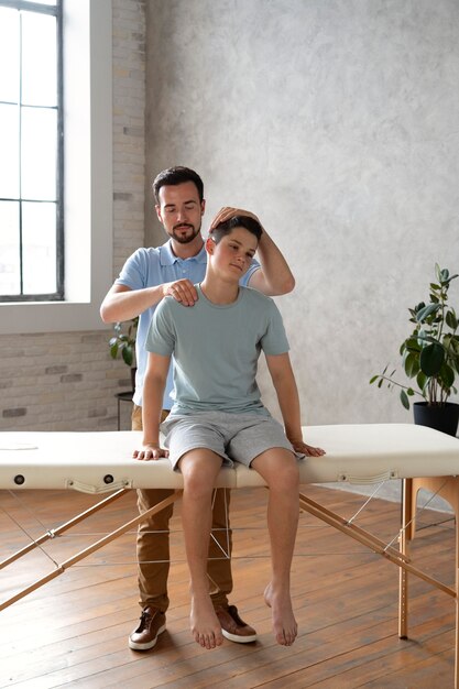 Hombre ayudando al paciente en fisioterapia full shot