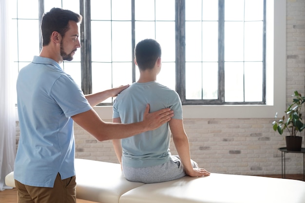 Hombre ayudando al paciente en fisioterapia plano medio