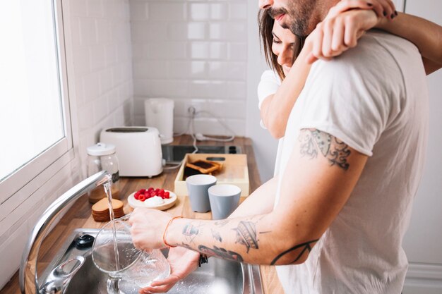 Hombre ayudando a mujer con platos