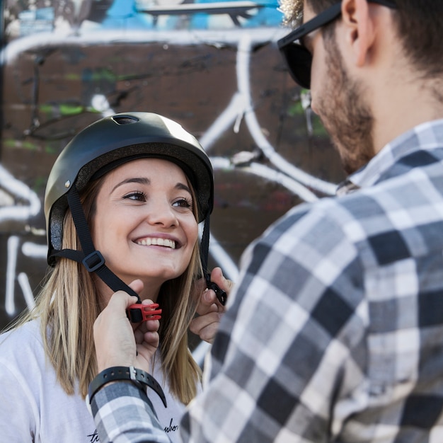 Foto gratuita hombre ayudando a la mujer a ponerse el casco