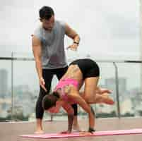 Foto gratuita hombre ayudando a la mujer a practicar yoga