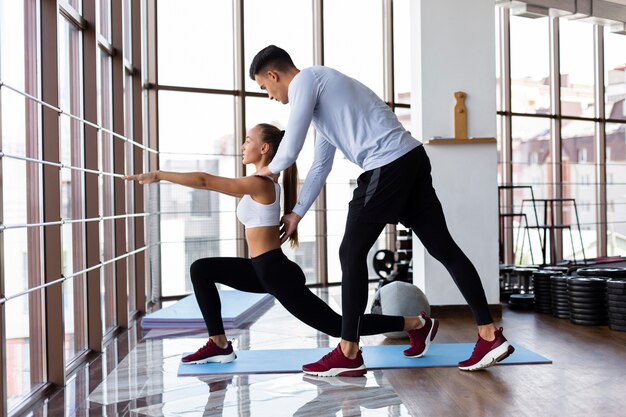 Hombre ayudando a mujer con su entrenamiento