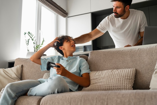 Foto gratuita hombre ayudando a niño con piojos de ángulo bajo