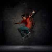 Foto gratuita hombre bailando contra una pared de ladrillo oscuro