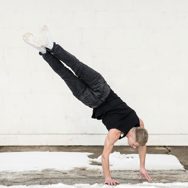 Foto gratuita hombre bailando hip hop mientras está parado en ambas manos