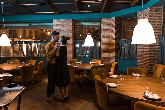 Hombre bailando con mujer en restaurante