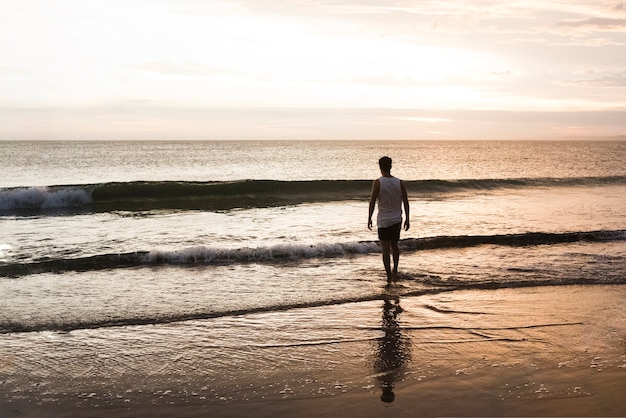 hombre bañándose en el océano al amanecer