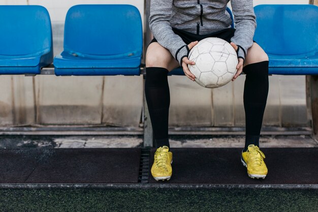 Hombre en banco sujetando pelota