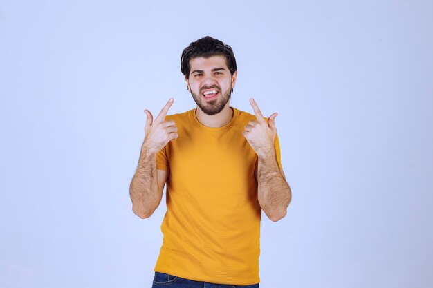 Hombre con barba apuntando a algo detrás