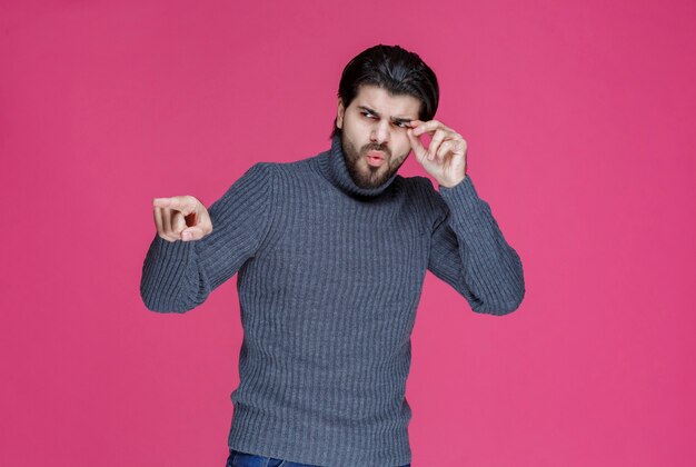 Hombre con barba apuntando a algo o presentando a alguien.