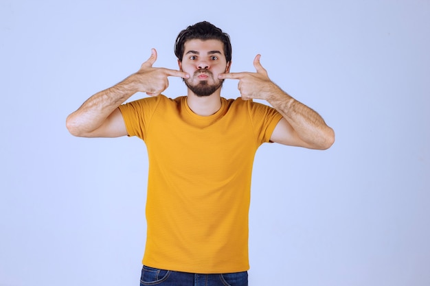 Hombre con barba apuntando a su boca