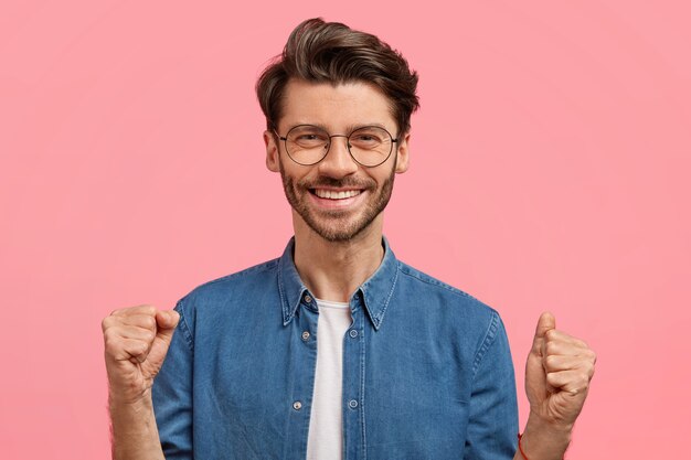 Hombre con barba en camisa vaquera y gafas redondas