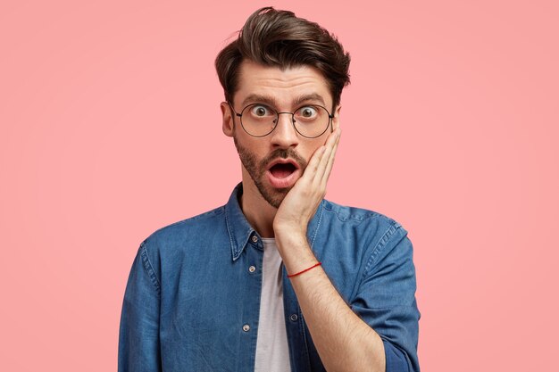 Hombre con barba en camisa vaquera y gafas redondas