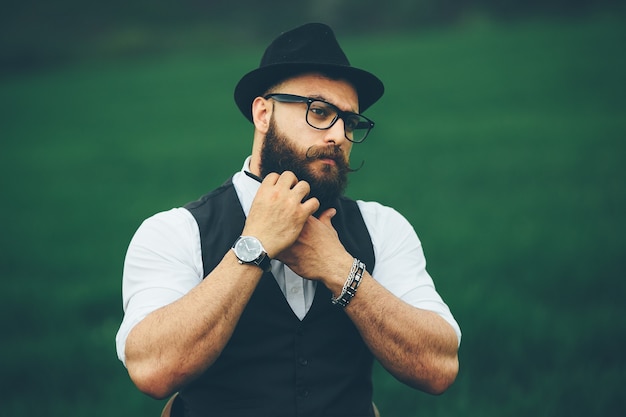 Foto gratuita hombre con barba y gafas en el campo verde