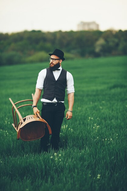 Hombre con barba y gafas de sol en el campo verde