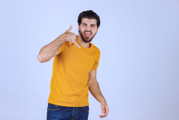 Hombre con barba haciendo señal de llamada