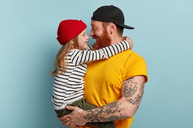 Foto gratuita hombre con barba pelirroja sosteniendo a su hija