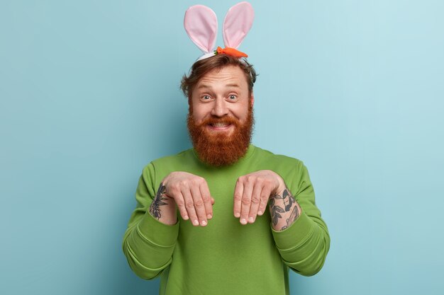 Hombre con barba pelirroja vistiendo ropas coloridas y orejas de conejo