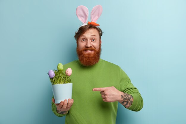 Hombre con barba pelirroja vistiendo ropas coloridas y orejas de conejo