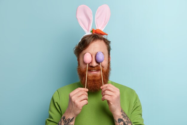 Hombre con barba pelirroja vistiendo ropas coloridas y orejas de conejo