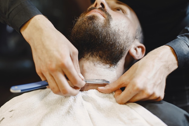 Hombre con barba. Peluquería con cliente. Hombre con un afeitado.