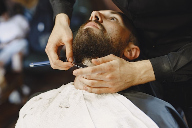 Hombre con barba. Peluquería con cliente. Hombre con un afeitado.