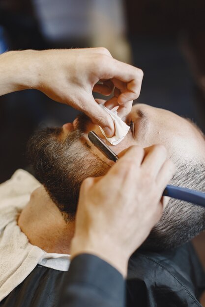 Hombre con barba. Peluquería con cliente. Hombre con un afeitado.