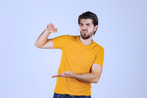 Hombre con barba que muestra las medidas estimadas de un objeto.