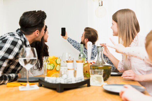 Foto gratuita hombre con barba que toma selfie con amigos