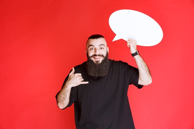 Foto gratuita hombre con barba sosteniendo un thinkboard ovale y pidiendo una llamada.