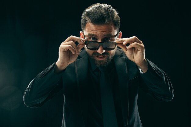 El hombre con barba en un traje de negro