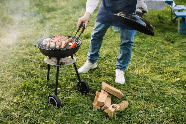 Hombre con una barbacoa en la naturaleza