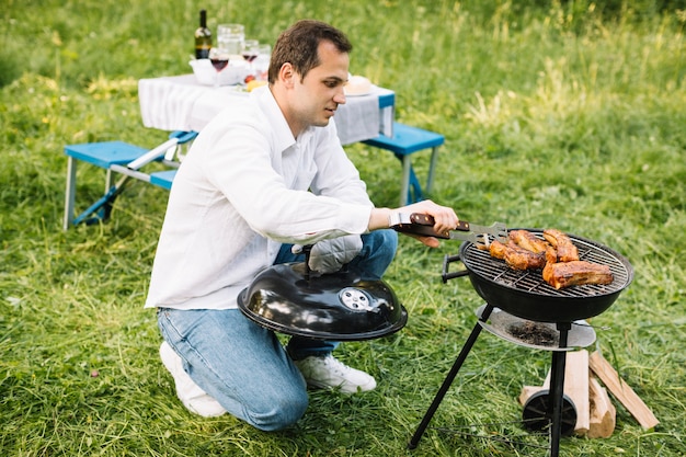 Hombre con una barbacoa en la naturaleza