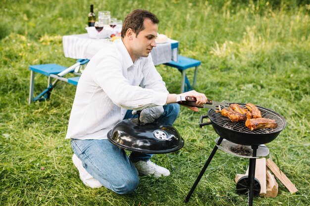 Hombre con una barbacoa en la naturaleza