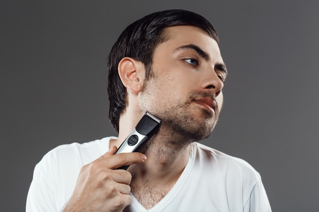 Hombre barbudo afeitarse la barba, preparándose