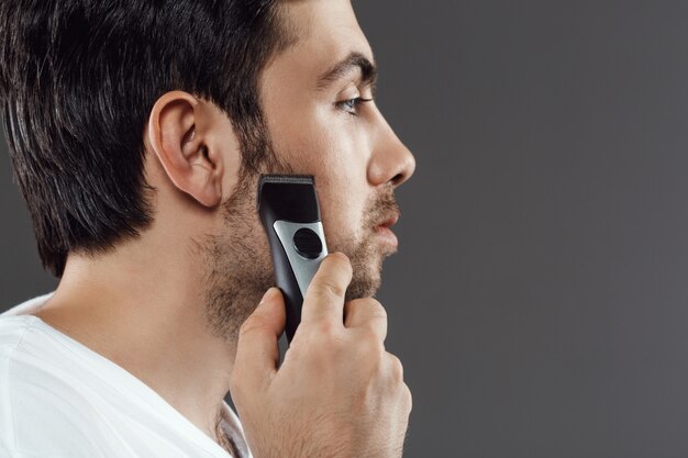 Hombre barbudo afeitarse la barba, preparándose