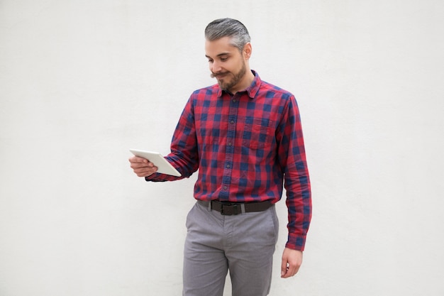 Hombre barbudo alegre con tablet pc