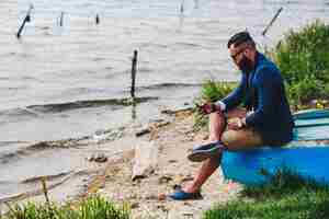 Foto gratuita hombre barbudo americano mira a la orilla del río con una chaqueta azul