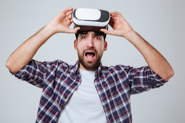 Hombre barbudo en camisa con dispositivo de realidad virtual