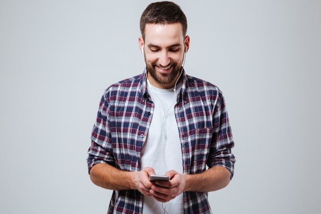 Foto gratuita hombre barbudo en camisa con smartphone