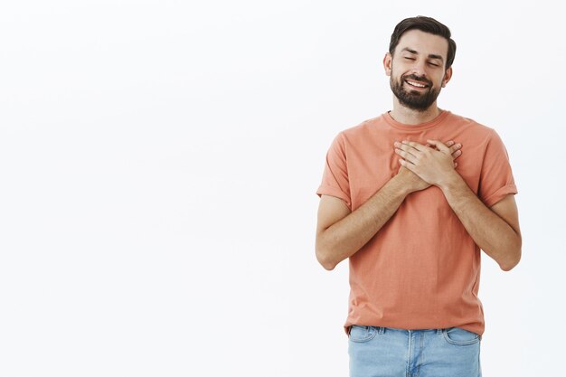 Hombre barbudo expresivo en camiseta naranja