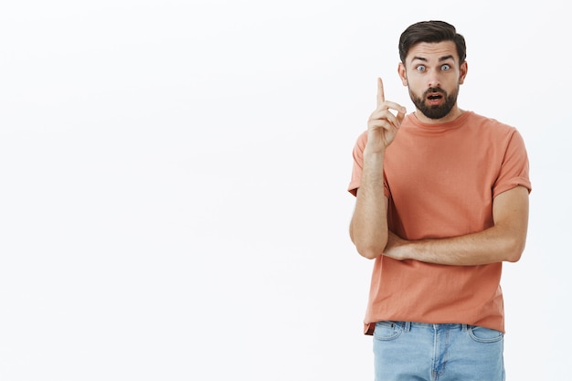 Hombre barbudo expresivo en camiseta naranja